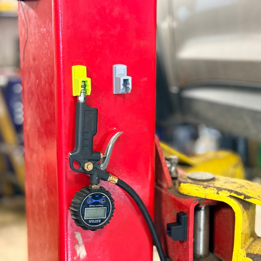 A tire inflator hanging from a dock on a red lift post