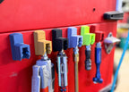 Red tool chest with various tools attached using magnetic holders.