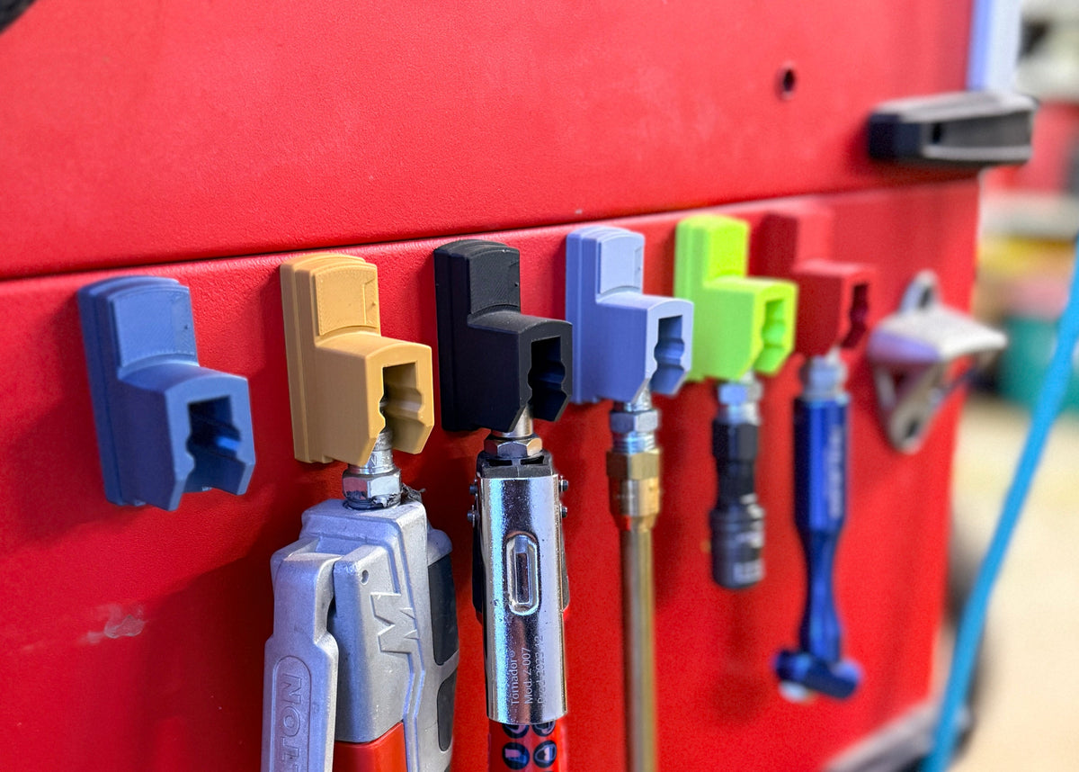 Red tool chest with various tools attached using magnetic holders.