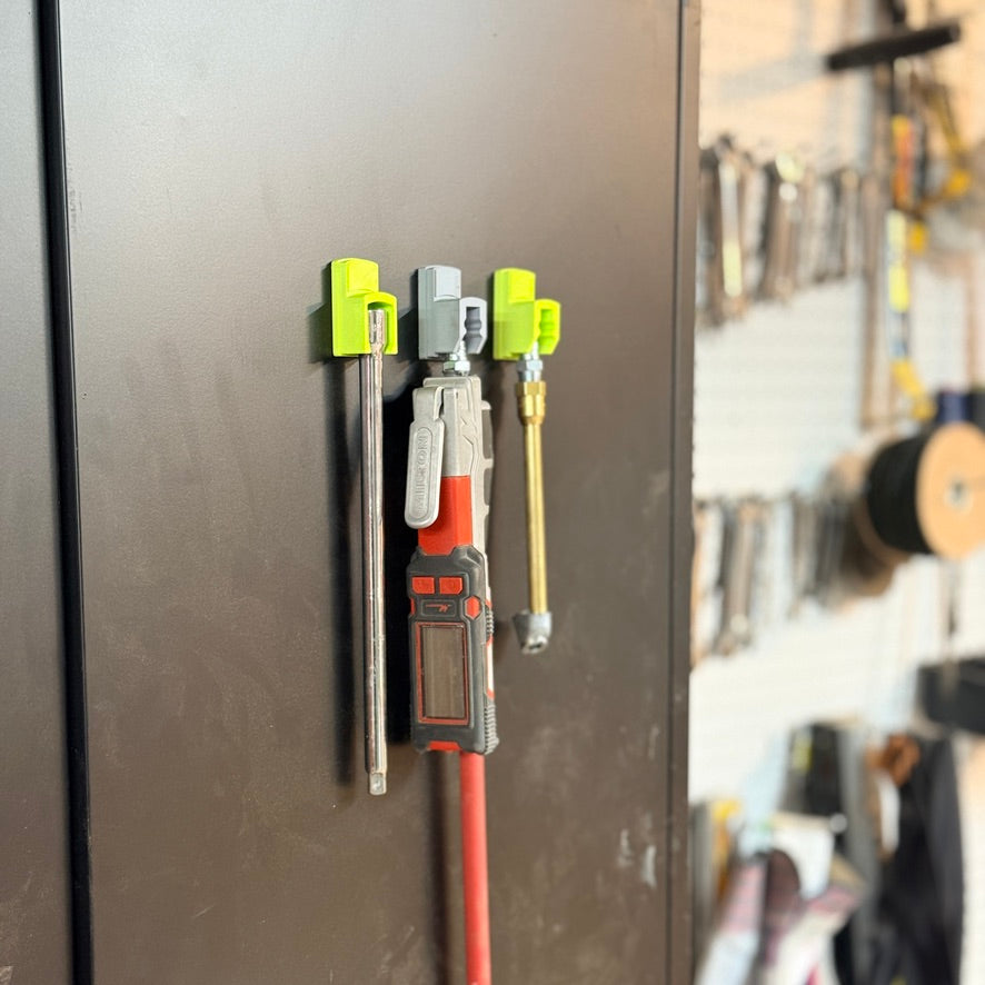 Air tools hanging from magnetic docks on the side of a toolbox